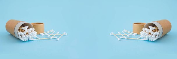 Баннер с бамбуковыми хлопковыми палочками в многоразовой бумажной упаковке трубки на модном синем фоне. Копировальное пространство для вашего дизайна, концепция нулевых отходов
 - Фото, изображение