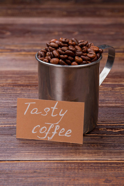 Steel mug full of roasted coffee beans. - Photo, Image