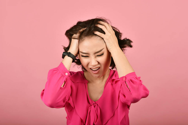 Mujer asiática enojada, Chica gritando con gesto agresivo furioso de la mano sobre fondo rosa, Expresión de la cara y emoción humana
. - Foto, imagen