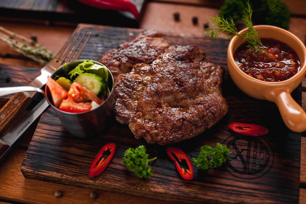 Beef steak with chilli on a wooden table. - Foto, immagini