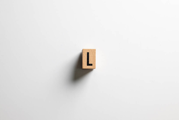 " L "κείμενο από ξύλινο κύβο σε λευκό φόντο με μονοπάτι απόληξης. - Φωτογραφία, εικόνα