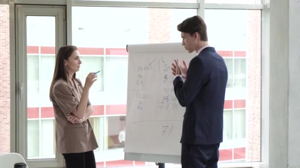 Két professzionális üzleti coaches vállalati vezetők tanárok flip chart előadás magyarázza grafikonon konzultálni ügyfelek képzése dolgozók csoport konferencia találkozó iroda csapat workshop tanácsteremben - Felvétel, videó