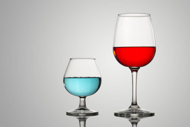 Lasi kupit nestettä tai juomia punainen ja sininen väri - Valokuva, kuva