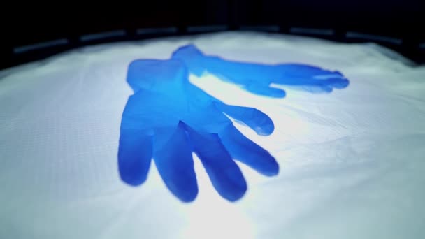 Niebieskie rękawice medyczne na lampie operacyjnej. Rękawiczki lekarza, który ratuje ludzi. Chroń ręce przed wirusami. Światowa pandemia, światowy kryzys. Dowódca-19. Koronawirus - Materiał filmowy, wideo