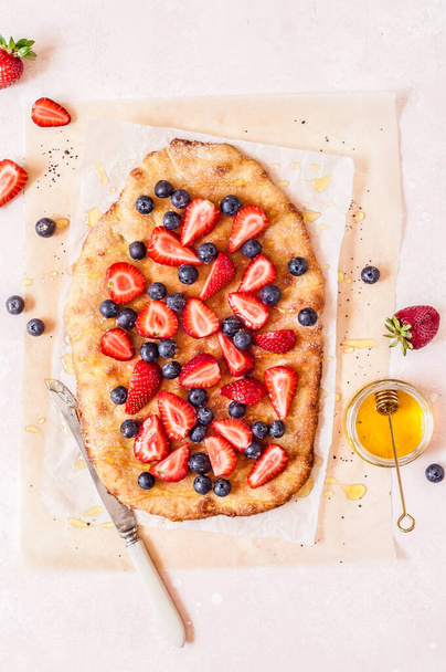 Summer Flatbread with Fresh Strawberries, Blueberries and Honey, Colors of American Flag for Independence Day 4th July, copy space for your text - Фото, изображение