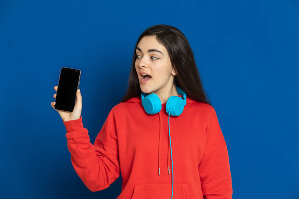 Bruna giovane ragazza che indossa maglia rossa su uno sfondo blu
 - Foto, immagini
