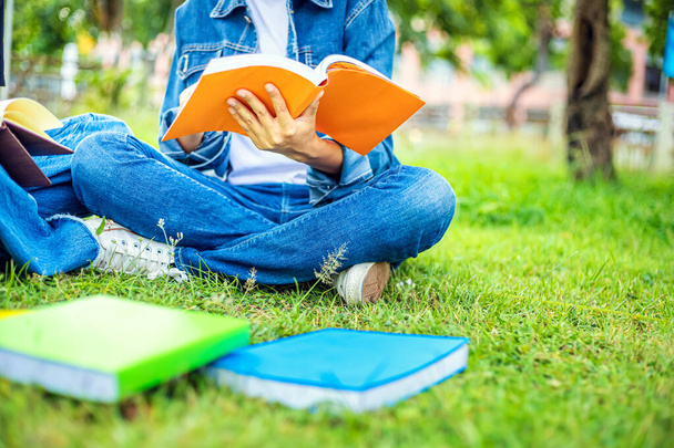 University students sit and read on the grass in the evening - Photo, image