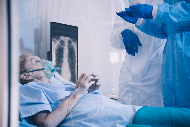 Fertőzött beteg takecare orvos és nővér röntgen tüdő karanténban feküdt az ágyon a kórházban a coronavirus covid 19 betegség. Covid19 vagy corona vírus a világ globális társadalmi kérdés koncepciója. - Fotó, kép