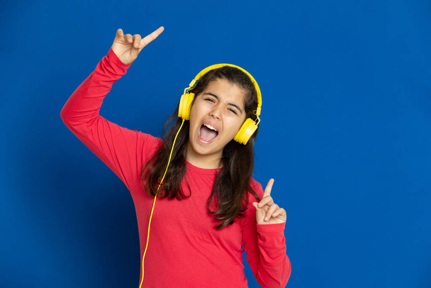 Adorable preteen girl with red jersey on a blue background - Photo, Image
