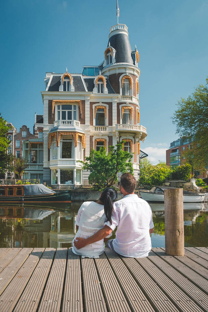 Історичний центр Амстердама, Нідерланди, чоловіки і жінки під час поїздки в місто навесні 2020 року, подружжя відвідує місто Амстердам під час спалаху вірусу Корона 19,  - Фото, зображення