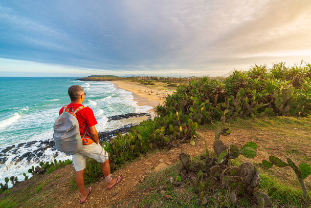 Человек с рюкзаком смотрит на тропическое побережье сверху. Вьетнамское направление путешествия, провинция Фу Йен между Да Наном и Нячангом. Bai Xep великолепный золотистый песчаный пляж с голубым морем
 - Фото, изображение