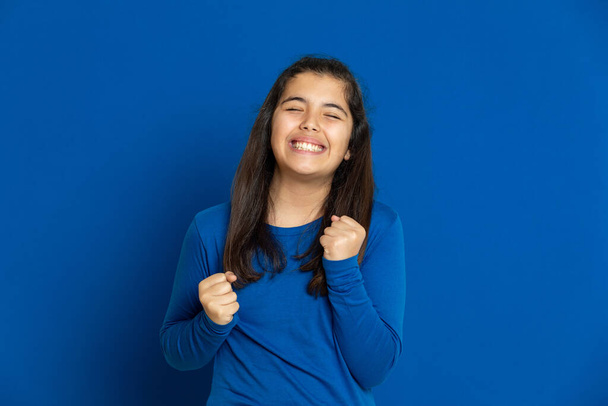Schattig tiener meisje op een blauwe achtergrond - Foto, afbeelding