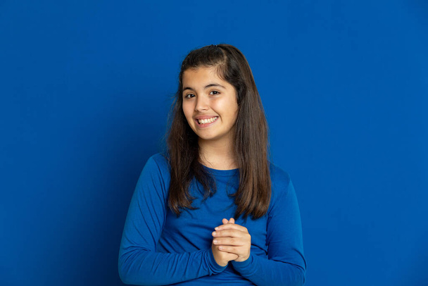 Brunette young woman wearing a yellow T-shirt on a blue background - Foto, Bild