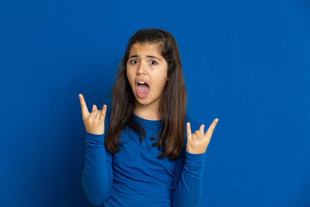 Adorável menina pré-adolescente com camisa azul em um backgroun azul
 - Foto, Imagem