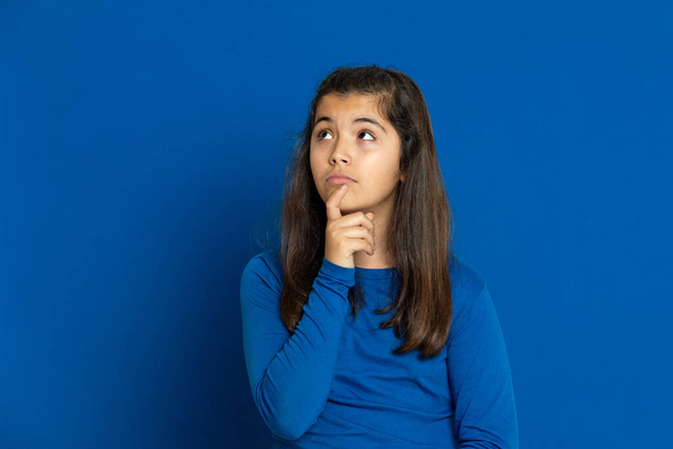 Adorable chica preadolescente con jersey azul sobre un fondo azul
 - Foto, imagen
