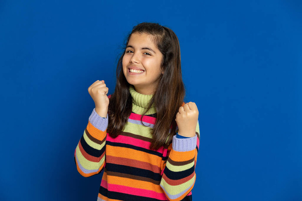 Adorável menina pré-adolescente com camisa listrada em um fundo azul
 - Foto, Imagem