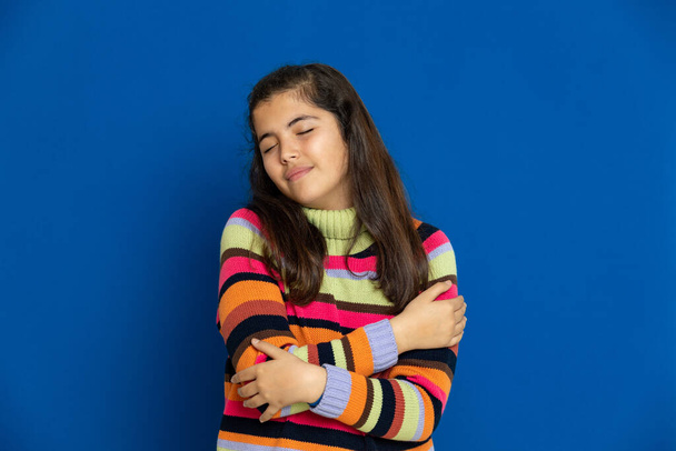 Adorabile preteen ragazza con jersey a righe su uno sfondo blu
 - Foto, immagini