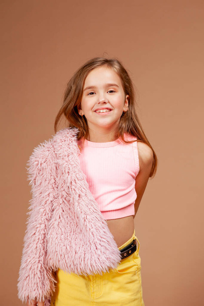 girl in a pink top and a yellow skirt on a beige background - Фото, зображення