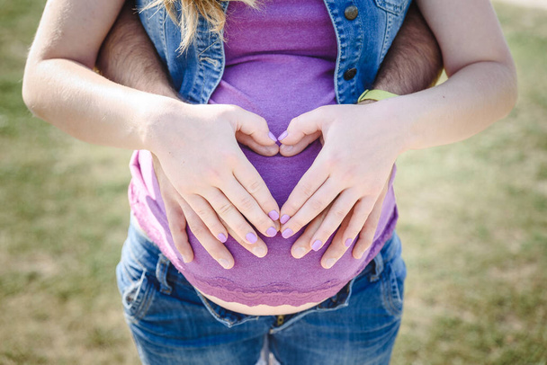 mulher grávida segurando sua barriga com o marido
 - Foto, Imagem