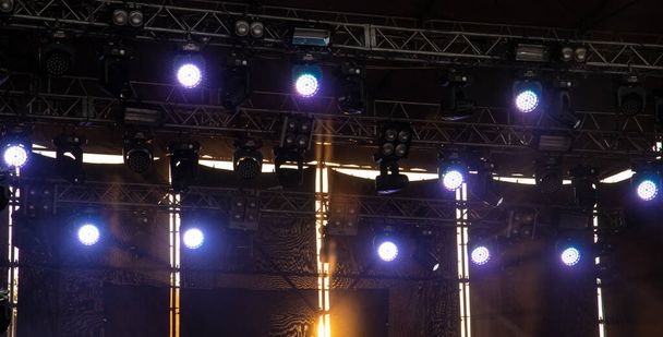 μουσική σκηνή φωτισμός λαμπτήρα φως λάμψη δραματικά χρώματα τεχνολογία εικόνα το βράδυ με πορτοκαλί φωτισμό πίσω από την κατασκευή - Φωτογραφία, εικόνα