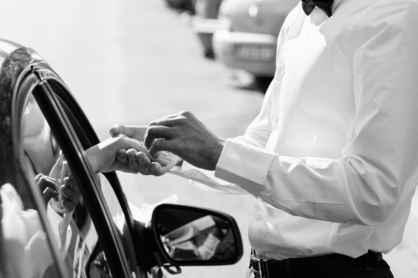 Ніжний тримає руки біля машини з весільною парою з кільцем Блек
 - Фото, зображення