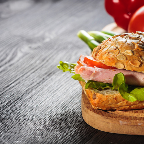 Jambonlu sandviç marul üzerinde tahta arka plan ile - Fotoğraf, Görsel