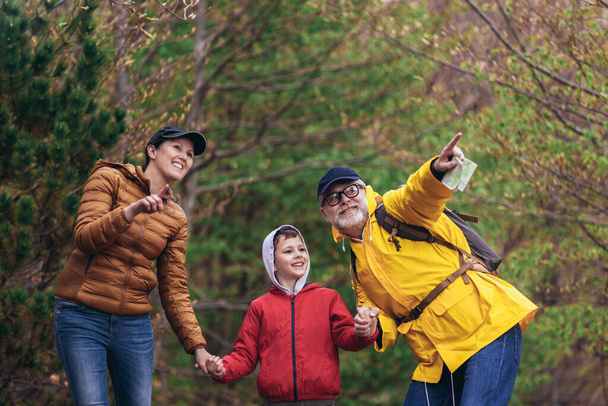 Boldog család séta hátizsákkal az erdőben, és szórakozás. - Fotó, kép