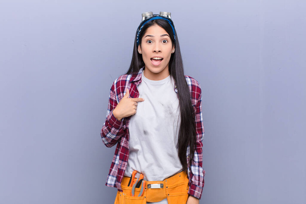young latin woman looking happy, proud and surprised, cheerfully pointing to self, feeling confident and lofty - Foto, imagen