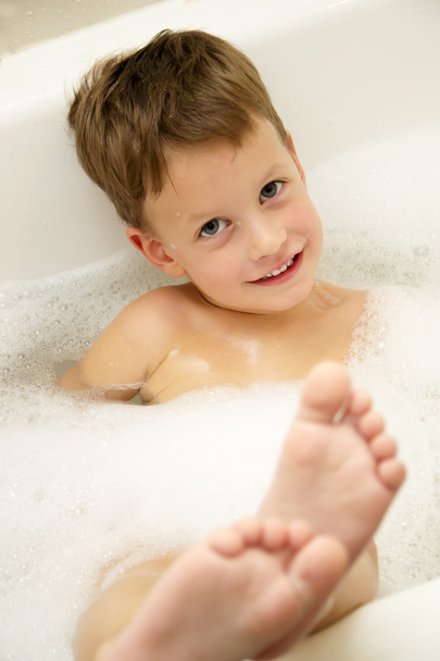 Cute three year old boy taking a bath with foam - Photo, image