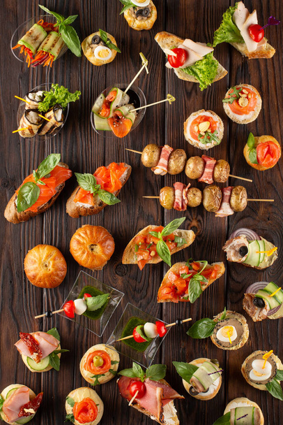 Set of different food snacks and appetizers on wooden background. Beautiful catering banquet buffet table. - Foto, Imagen