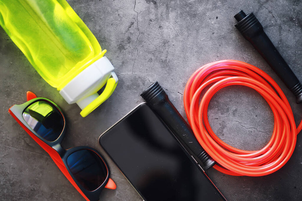 Jump rope. Physical education. Sports exercise equipment. Rope exercises routine. Pink jump rope stopwatch and water on the table. - Foto, afbeelding