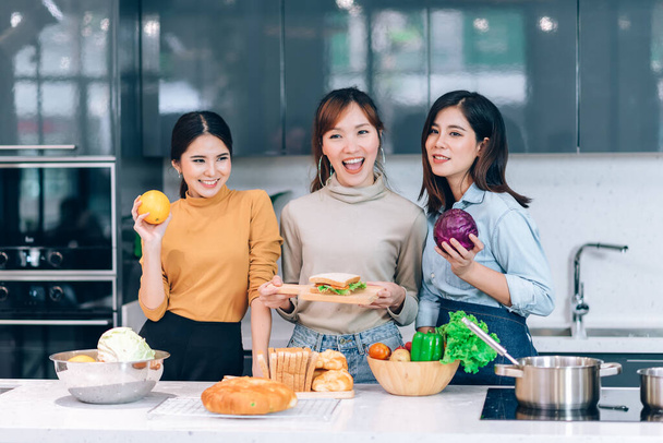 Felices amigos asiáticos cocinando juntos en la cocina en casa - Hobby Lifestyle Concept - Foto, Imagen
