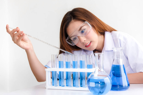 Молодые азиатские ученые проводят эксперименты с научным оборудованием в области химико-биологических испытаний и исследований на белом фоне с копировальным пространством - Фото, изображение