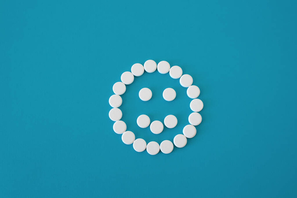 Pills positive smile on blue background, smile is centered , concept mood, isolated - Фото, изображение