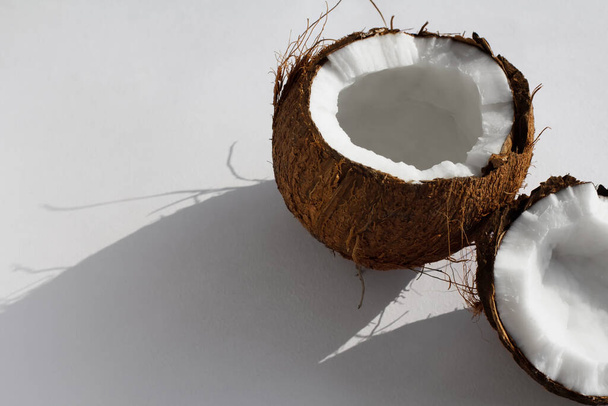 broken coconut on a white background with coconut milk. diet product. healthy food. vegan food - Photo, Image