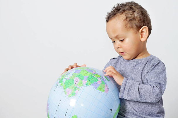 Image of a boy holding globe on earth day - Foto, Bild