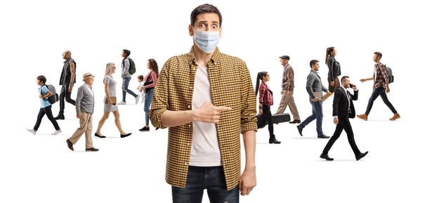 Disappointed man with a protective face mask pointing at a group of people walking without masks isolated on white background - Photo, Image