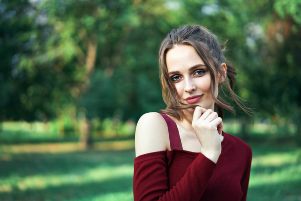 Portrait of young beautiful woman outdoors on green summer nature background. Female beauty concept      - Фото, изображение