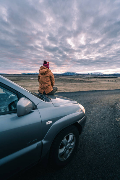 Με καλεί το ταξίδι. Ώρα για την περιπέτεια του δρόμου αρχίζει. Μια νεαρή μοναχική γυναίκα περιπέτεια ταξιδιώτη σε μια φύση με όμορφο ηλιοβασίλεμα ουρανό. Ισλανδία ταξίδια - Φωτογραφία, εικόνα
