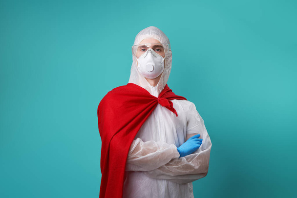 Lekarz nosi ŚOI - kostium, rękawiczki i maskę chirurgiczną w pelerynie superbohatera. - Zdjęcie, obraz