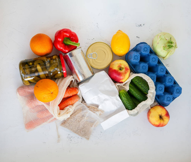 寄付のための異なる製品のセット。白を基調とした缶詰食品、米、卵、果物、野菜、トップビュー - 写真・画像