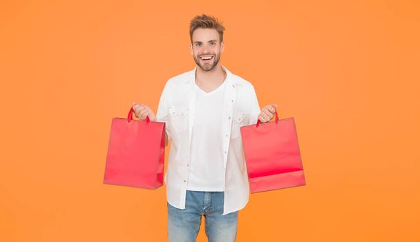 guy happy about his purchase. successful shopping online. male shopper hold packages. shopping bag with goods. How to save money while sale. cyber monday concept. goods for men - Photo, Image