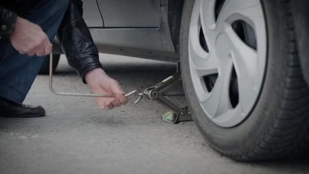 mechanikus emelő használata a kerék pótlására egy autón - Felvétel, videó