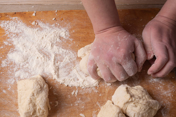 Mani femminili mescolando pasta nella cucina di casa
 - Foto, immagini