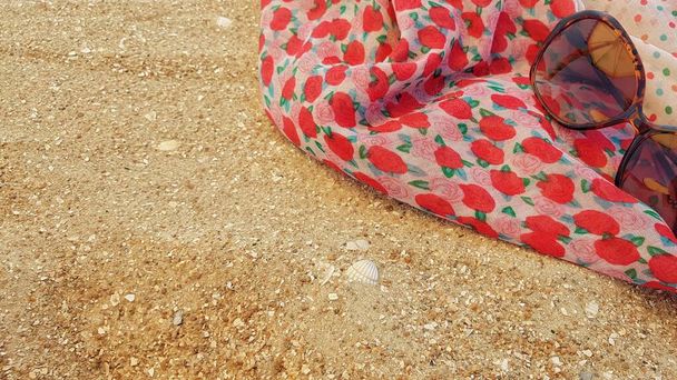 Парео и очки от солнца лежат на песке
 - Фото, изображение