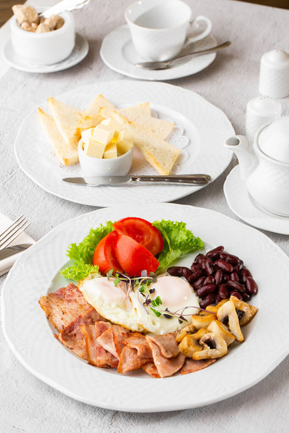 Poached eggs with vegetable, ham, tomatoes, red beans and sourdough toast isolated on white marble background. Homemade food. Tasty breakfast. Selective focus. - Foto, Imagen