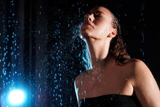 Wet beautiful woman under the falling drops of rain - Fotoğraf, Görsel
