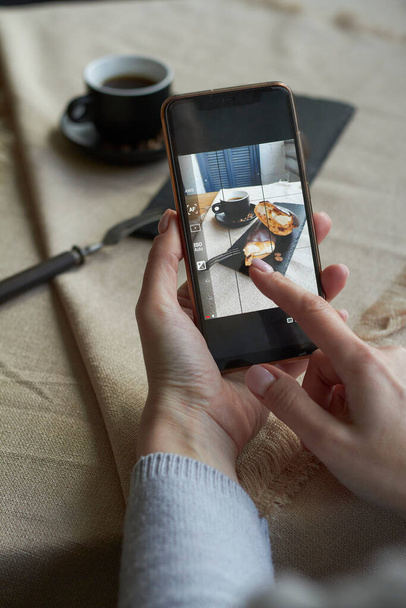 Blog yazarının akıllı telefondan fincanın fotoğrafını çekerken üst görünüm, seçici odaklanma - Fotoğraf, Görsel