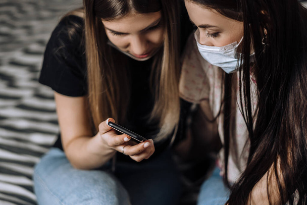 Two young females in medical protective masks. - Photo, image
