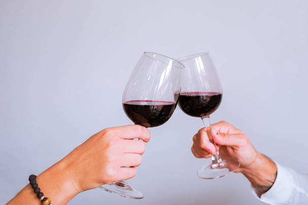 Lovers with wine glasses in the restaurant for the day of love. Cheers! Hands holding wine glass. Grey background.  Celebration, Wedding concept. Image - Photo, image